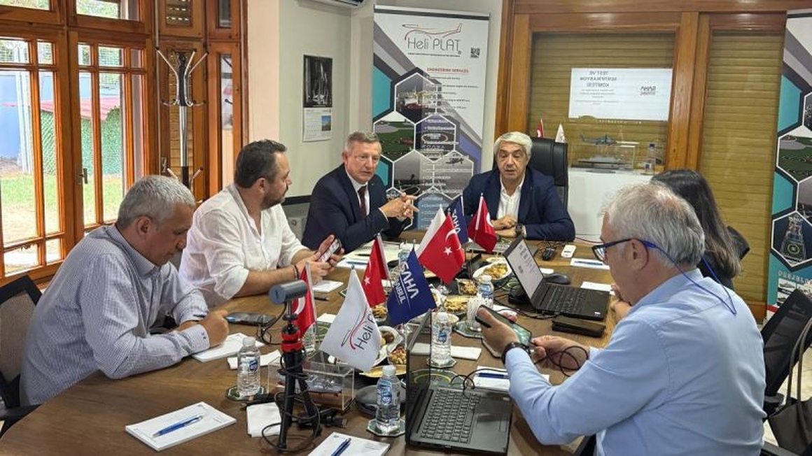 HELİPLAT toplantı salonunda komite üyeleri masa etrafında görüşme yaparken